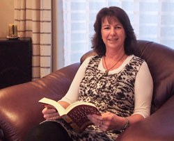 Fionna McCarthy sitting in a chair reading a book