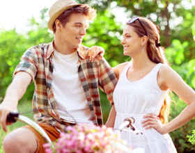 A couple standing outside looking at each other and smiling