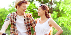 A couple standing outside looking at each other and smiling